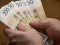 Dwie ręce trzymają plik banknotów 200 zł. Może to być zapłata za podatek ETS2.
