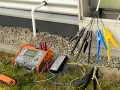 Pomiar rezystancji izolacji instalacji elektrycznej za pomocą miernika. Podłączone przewody z krokodylkami do badanych punktów.