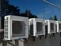 Kilka jednostek zewnętrznych klimatyzatorów Fujitsu zamontowanych na ścianie budynku. Zastanawiasz się, jaka pompa ciepła do domu 130m2?