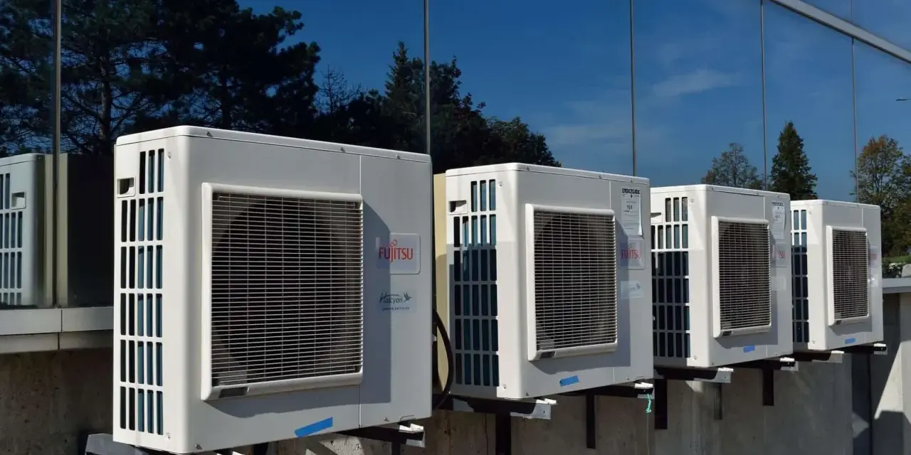 Kilka jednostek zewnętrznych klimatyzatorów Fujitsu zamontowanych na ścianie budynku. Zastanawiasz się, jaka pompa ciepła do domu 130m2?