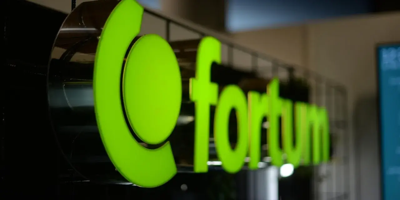 Jasnozielone, podświetlane logo Fortum Energia na metalowej konstrukcji.