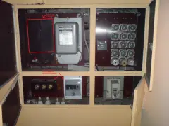 Zabezpieczenie przedlicznikowe w skrzynce z licznikiem energii elektrycznej i bezpiecznikami.