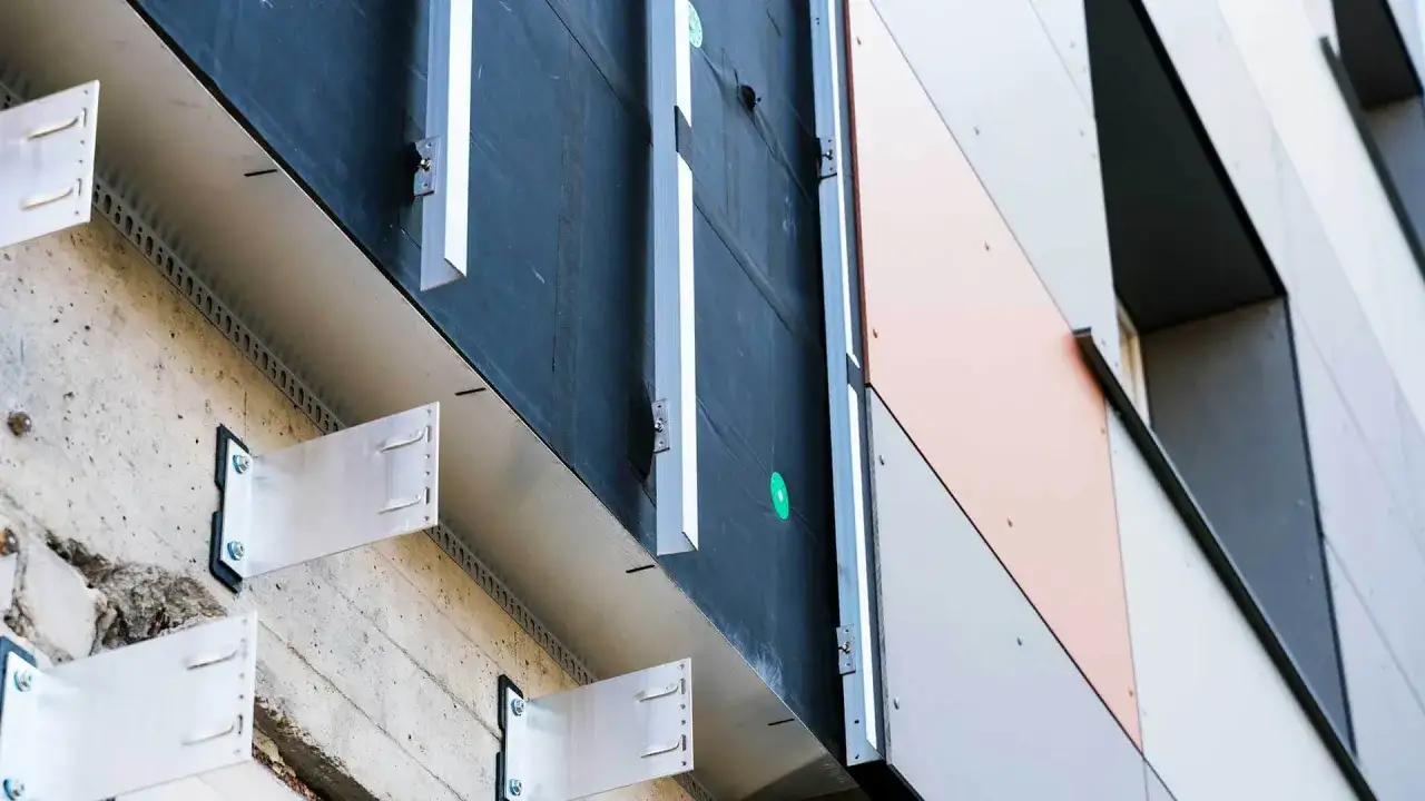 System mocowania paneli tworzy przestrzeń dla wentylacji, kluczową dla elewacji wentylowanej. Metalowe wsporniki łączą beton z warstwą izolacji i okładziną.