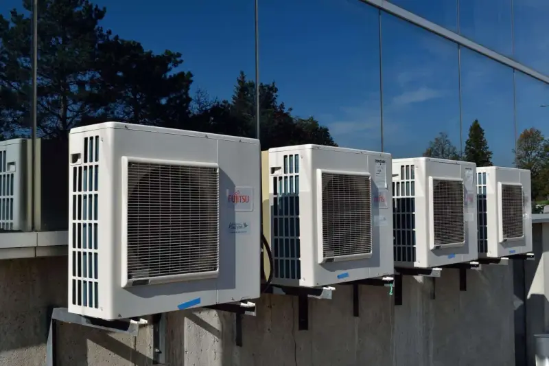 Kilka jednostek zewnętrznych klimatyzatorów Fujitsu zamontowanych na ścianie budynku. Zastanawiasz się, jaka pompa ciepła do domu 130m2?